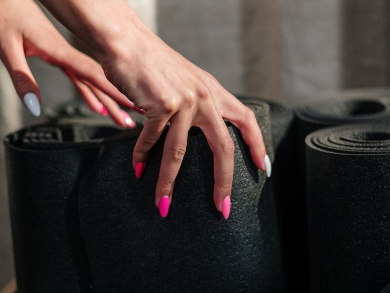 Detailed close-up of a yoga practitioner's hands on a mat.